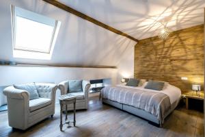 a bedroom with a bed and a chair and a window at Chante-Pierre in Gesves