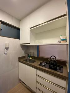a kitchen with a stove and a sink in it at Apartamento de Luxo em Boa Viagem Perto da Praia. in Recife