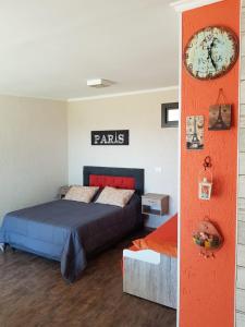 1 dormitorio con 1 cama y reloj en la pared en MIracampo en San Antonio de Arredondo