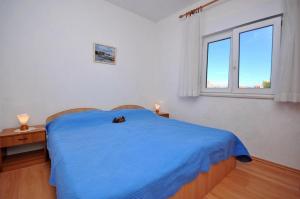 - une chambre avec un lit bleu et une fenêtre dans l'établissement Apartment Kate - with large terrace, à Postira