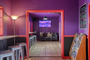 a dining room with purple walls and a doorway at Sin City Hostel in Las Vegas