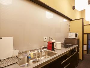 Una encimera de cocina con fregadero y microondas. en Rinn Kujofujinoki West, en Kioto