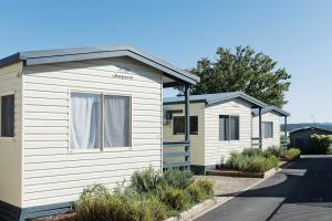 una fila de casas móviles en una calle en Crestview Tourist Park, en Queanbeyan