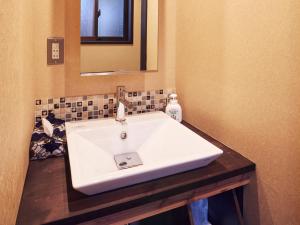 Un baño con un lavabo blanco y un espejo. en Rinn Kujofujinoki West, en Kioto 24 fotos más
