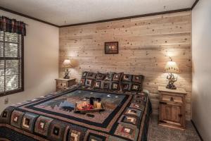 Cama en habitación con pared de madera en Canyon Cabins, en Ruidoso