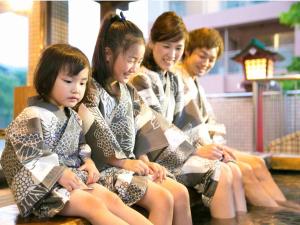 
three girls sitting on a counter with their hands on their hips at Ryochiku Bettei in Beppu

