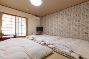 A bed or beds in a room at Tabist Business Ryokan Akashiya Annex