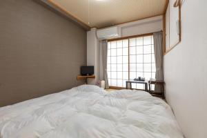 Un pat sau paturi într-o cameră la Tabist Business Ryokan Akashiya Annex