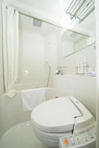a white toilet sitting in a bathroom next to a shower at Super Hotel Lohas JR Nara Eki in Nara