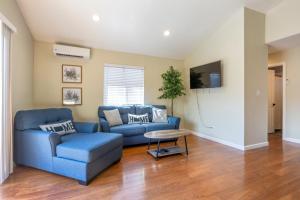 ein Wohnzimmer mit einem blauen Sofa und einem Tisch in der Unterkunft @ Marbella Lane 3BR House in Downtown San Jose in San Jose