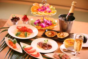 Hotel Lotus Koiwa (Adult Only) في طوكيو: طاولة مع أطباق من الطعام وزجاجة من النبيذ