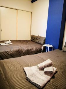 twee bedden in een kamer met handdoeken op het bed bij Yamanashi Grand chene Fuefuki #Gr4 in Isawa