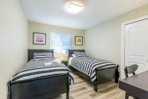 twee bedden in een kamer met een tafel en een bureau bij @ Marbella Lane NEW!3BR House in Downtown San Jose in San Jose