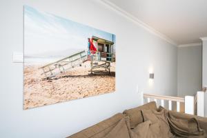 ein Wohnzimmer mit einem Gemälde eines Strandes in der Unterkunft Meer-Lust-Sylt Haus Mateika in Westerland