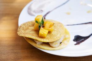 a plate with two tacos with pineapple on it at Basecamp Yoga Beach House in Weligama