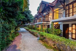 a path leading to a building with a house at The Monttra Pattaya - SHA Extra Plus in Pattaya South