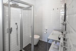 a bathroom with a shower and a toilet and a sink at La Falconeria Hotel in Valletta