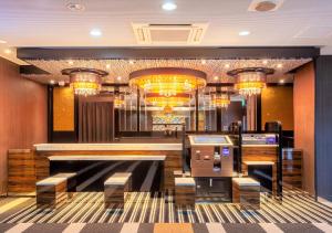 a bar in a hotel with chandeliers and benches at APA Hotel Saga Ekimae Chuo in Saga