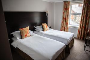 a hotel room with two beds and two lamps at The Beaumont Hexham in Hexham