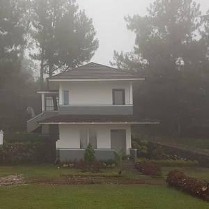 a house on a foggy day in front of a house at Neo Akshaya Vila and Camping Ground in Bogor