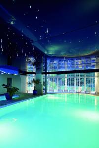 a swimming pool in a building at night at Hotel Molitors Mühle in Eisenschmitt