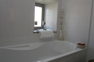 Domaine du Grand Tourtre في Chalais: حوض استحمام أبيض في حمام مع نافذة