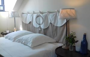 - une chambre avec un lit avec un rideau et deux lampes dans l'établissement Villa Pen Prad, à Sauzon