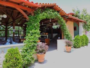 an arch with plants and flowers in front of a building at Julia Hotel in Fourka
