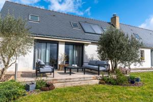 ein Haus mit einer Terrasse mit 2 Stühlen und einem Tisch in der Unterkunft BELLILOIRE, Chambre à la campagne in Belligné