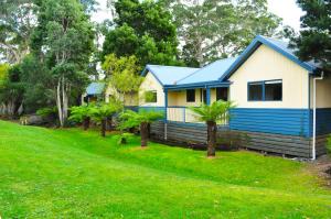 a blue and white house with a yard at BIG4 Strahan Holiday Retreat in Strahan