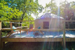 een yurt met een tafel en stoelen op een terras bij Les Yourtes de Provence in Saint-Paulet-de-Caisson