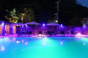 a swimming pool at night with blue and purple lights at Amis Droles in Kawazu