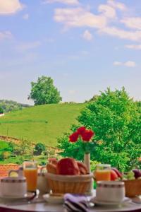 a table with a plate of food and a bowl of fruit at Relais Des Tilleuls in Hasparren +18 photos