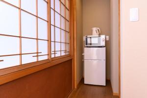 a microwave on top of a refrigerator next to a window at BEYOND HOTEL Takayama 4th in Takayama