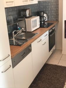 a kitchen with a sink and a microwave at Ferienwohnung im Herzen der Holledau in Pörnbach