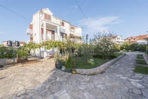 una casa con una pasarela de piedra frente a un edificio en Apartments Summertime, en Srima