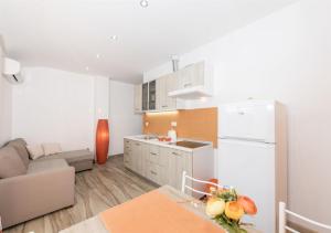 cocina con nevera blanca y sofá en Apartments Summertime, en Srima