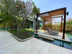 a swimming pool with a bench next to a house at The Garden 304 in Si Maha Phot