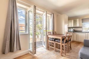a kitchen and dining room with a table and chairs at Heathrow Apartment - private balcony & FREE PARKING! in Slough