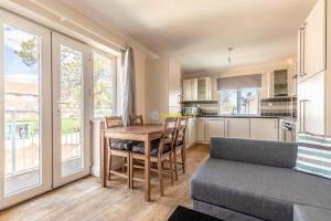 a kitchen and dining room with a table and a couch at Heathrow Apartment - private balcony & FREE PARKING! in Slough