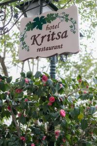 a sign for a hotel kittasma restaurant next to a bush at Gastronomy Hotel Kritsa in Portaria
