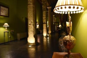 a lamp sitting on top of a table in a room at HOTEL RURAL A VELHA FABRICA in Valverde del Fresno