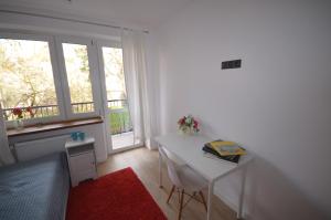 a bedroom with a desk and a bed and a window at Blue Sail Sopot Apartments in Sopot