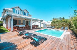 - une piscine sur une terrasse en bois à côté d'une maison dans l'établissement Maison la pointe, à Le Tampon