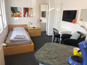 a small bedroom with a bed and a table at Apartmenthaus Somborn in Bochum