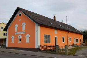 ein orangefarbenes und weißes Gebäude mit einem schwarzen Dach in der Unterkunft "Nesthocker" Café-Snackbar-Pension-Bauwagencamp in Offingen