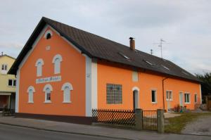 un edificio naranja y blanco con techo negro en "Nesthocker" Café-Snackbar-Pension-Bauwagencamp, en Offingen