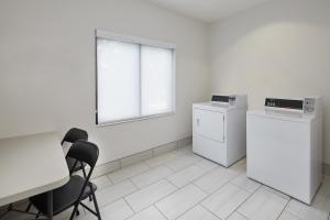 a room with a table and chairs and a window at Holiday Inn Express Hotel & Suites Pensacola-West Navy Base, an IHG Hotel in Pensacola