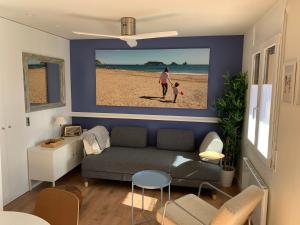 un soggiorno con divano e una foto di una spiaggia di Mas PineII 2 - Viu Bé a Torroella de Montgrí