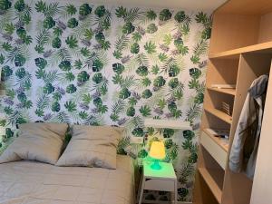a bedroom with a bed with a green and white wallpaper at Mas PineII 2 - Viu Bé in Torroella de Montgrí